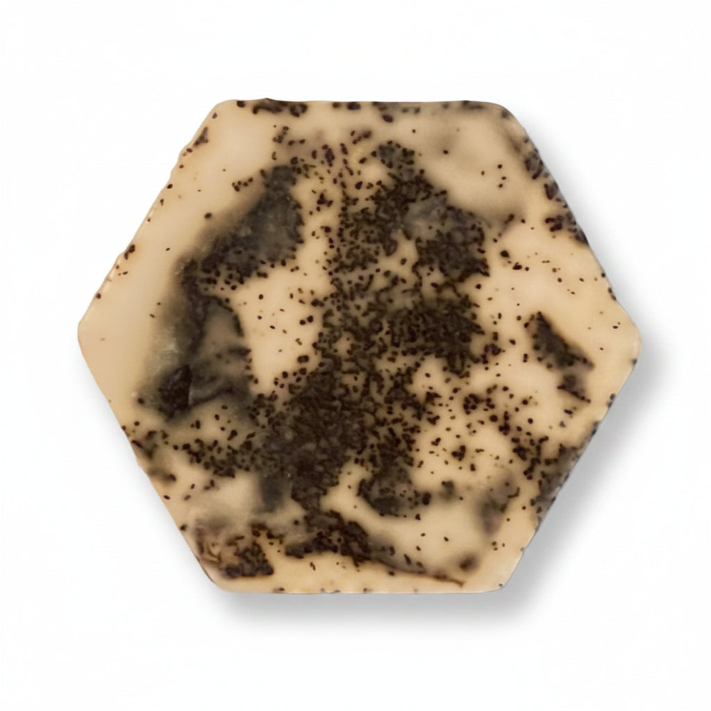 Hexagonal soap bar with a cream and dark speckled pattern on a white background