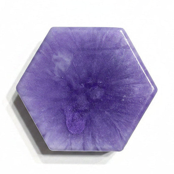 A hexagonal purple stone cabochon with natural marbled patterns, photographed on a clean white background with a soft drop shadow.
