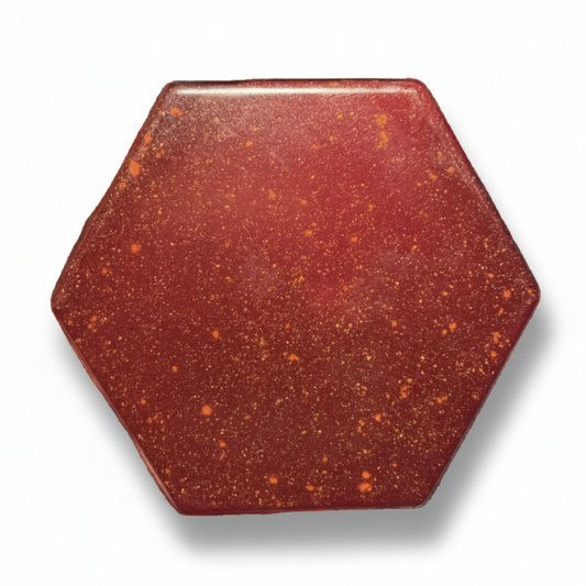 A hexagonal red stone or gemstone with tiny golden inclusions, shown on a black background within a mobile app interface.
